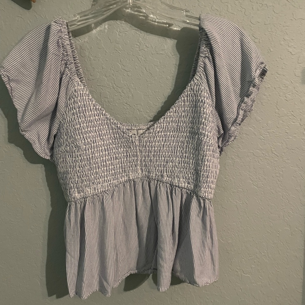 A white and blue striped women's blouse in the size medium